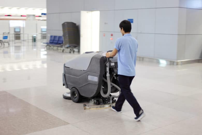 Peking, China - May 1, 2009: cleaning up; man is cleaning an airport floor (Peking) with a washer