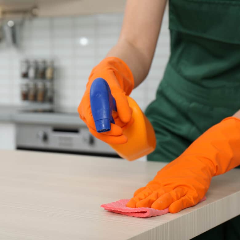Female janitor cleaning table with rag in kitchen, closeup. Space for text; Shutterstock ID 1272011038; purchase_order: Multi DES (Fresh) / Ultra DES / Spray; job: ; client: ; other: